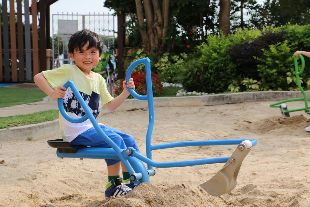 Hong Kong Gold Coast Hotel Exterior foto A child playing with a sandbox digger
